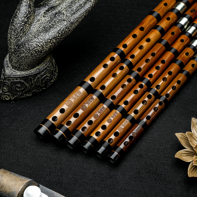 Close-up of Guo Xinming Professional Dizi flutes highlighting finger holes, tuning joints, and polished bamboo finish for advanced woodwind players.
